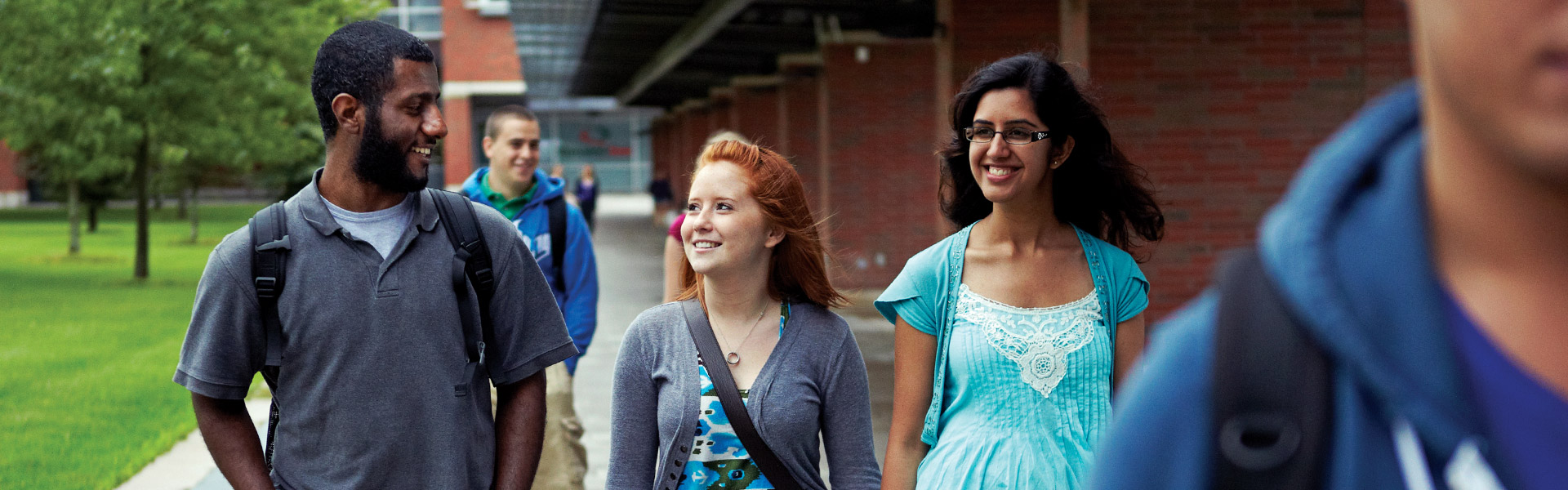 3 Students walking through the walkway in the Polonsky Commons during a tour